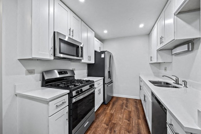 a kitchen with white cabinets and black appliances