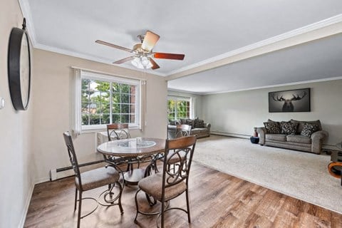 a living room with a dining room table and a ceiling fan