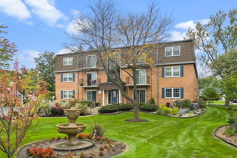 A large house with a fountain in front of it.