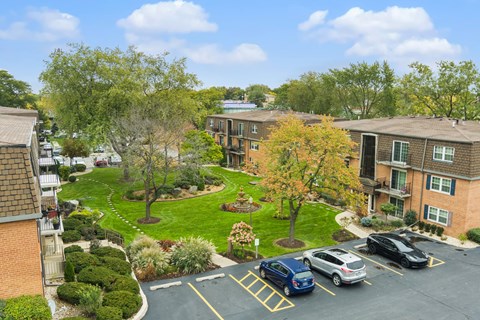 A parking lot with cars and apartment buildings in the background.