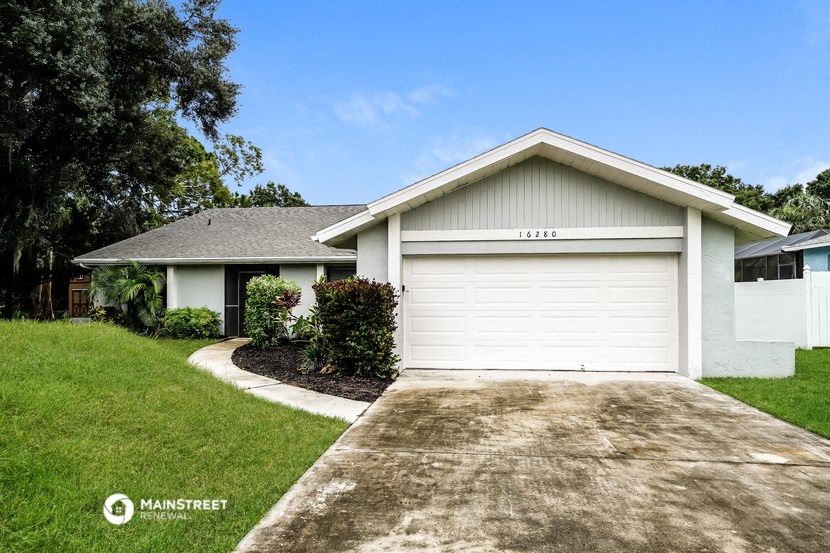 a white house with a driveway and a garage door