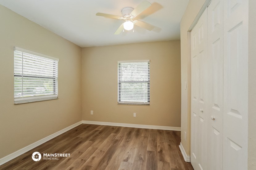 the master bedroom has a ceiling fan and hardwood floors