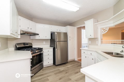 a white kitchen with stainless steel appliances and white cabinets