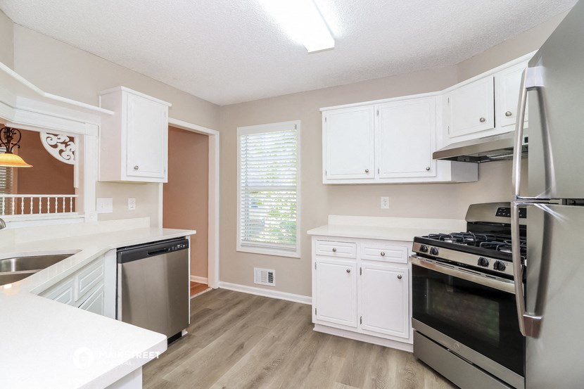 a kitchen with white cabinets and stainless steel appliances