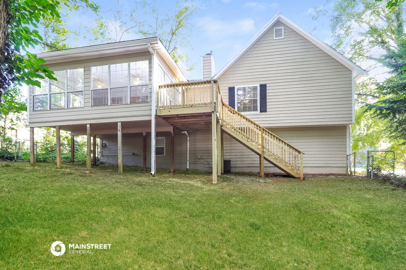 the back of a house with a deck on top of it