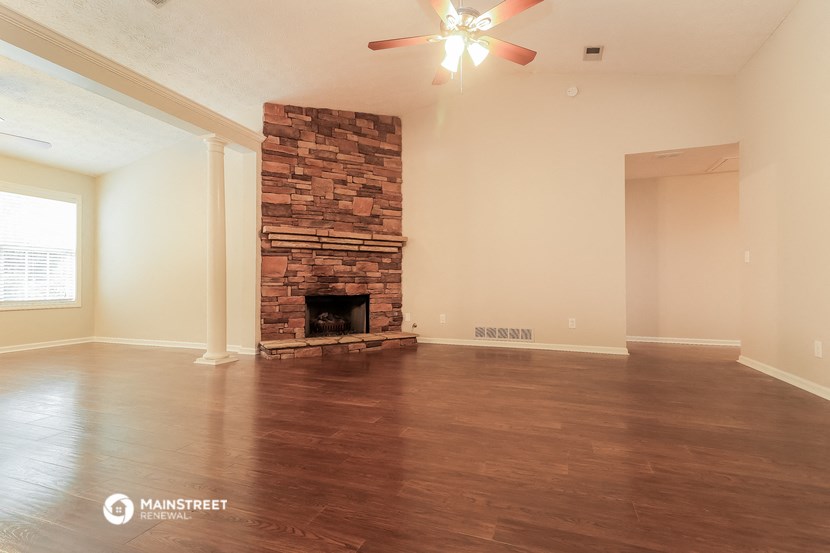 the living room with fireplace and wood flooring