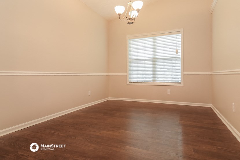 the spacious dining room with wood flooring and a window