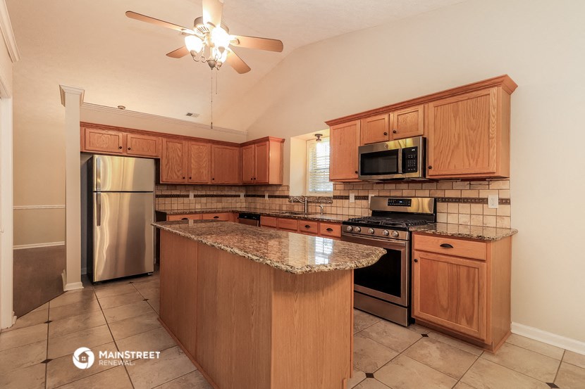 an updated kitchen with granite countertops and stainless steel appliances