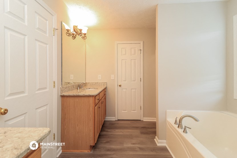 a bathroom with a tub and a sink and a door
