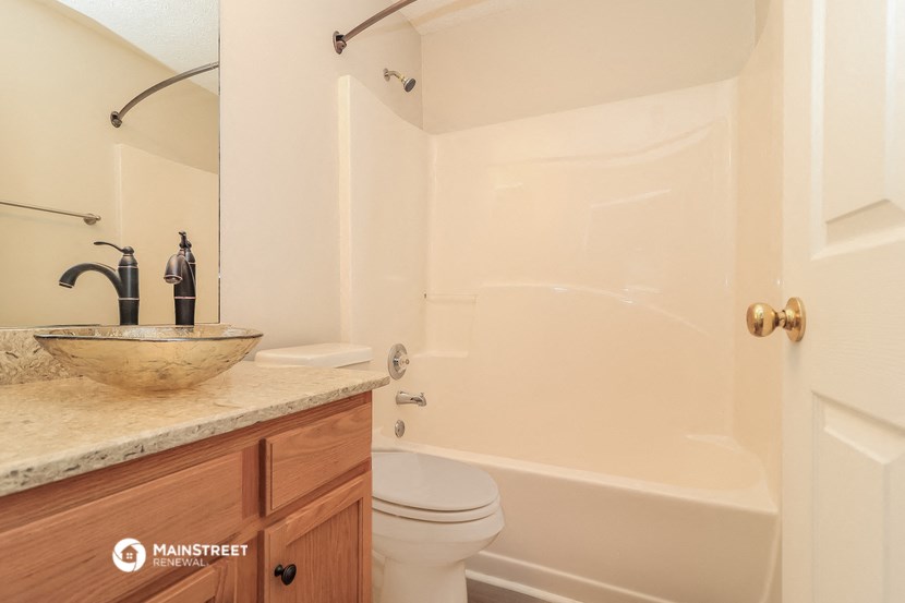 a bathroom with a toilet and a tub and a sink
