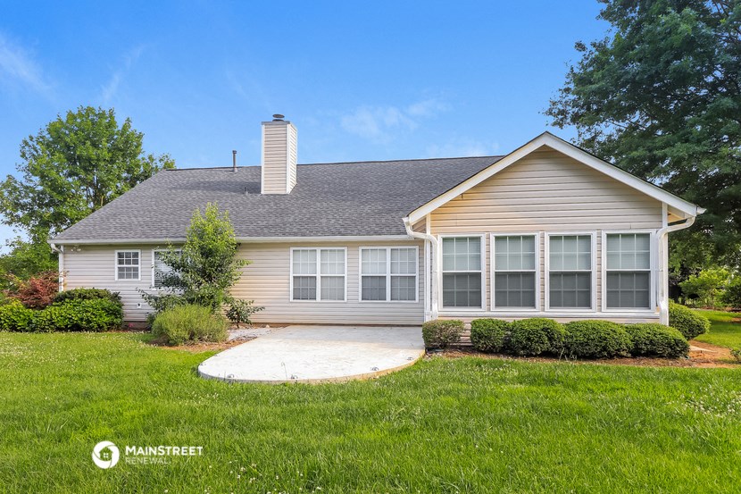 a small house with a yard and a driveway