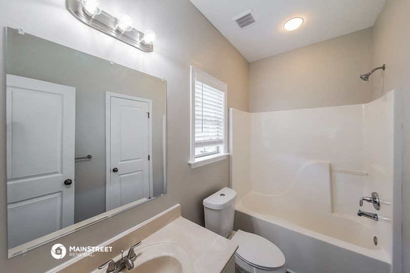 a bathroom with a toilet sink and a tub and a mirror