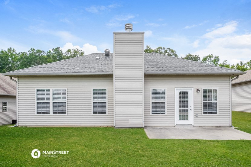 a white house with a gray roof and a driveway