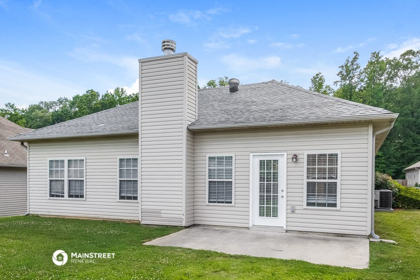 the front of a white house with a concrete driveway