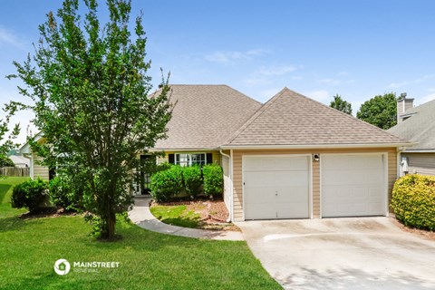 a house with a garage and a tree in front of it