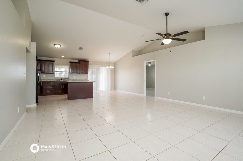 an empty kitchen and living room with a ceiling fan