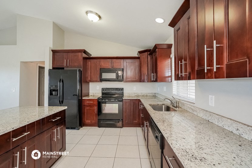 a kitchen with wood cabinets and granite counter tops and black appliances