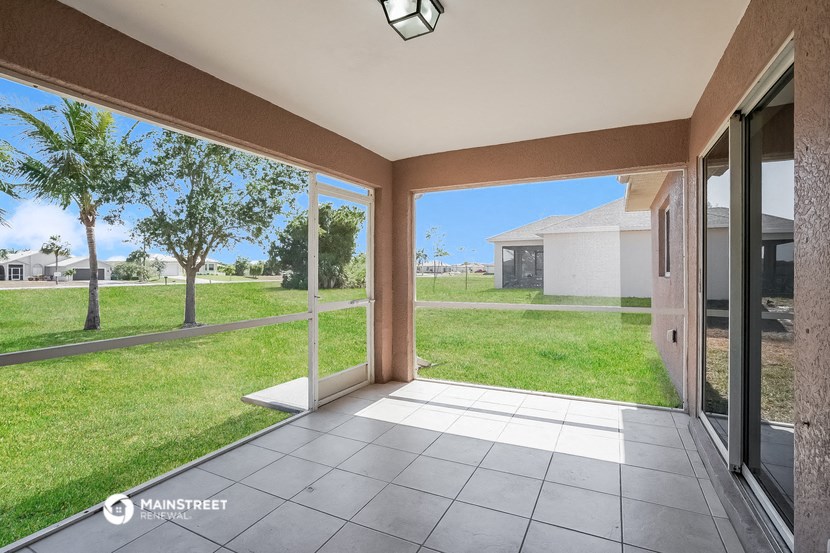 a view of the yard from the inside of a house with glass doors