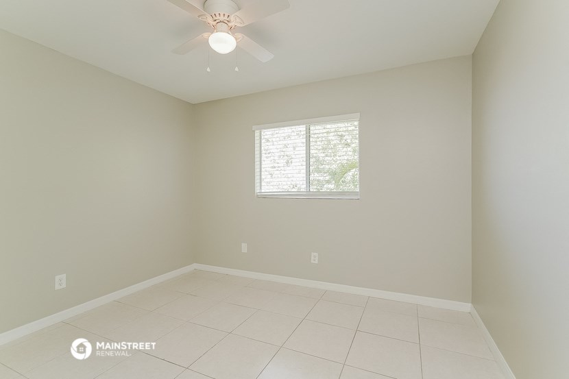 a empty room with a ceiling fan and a window