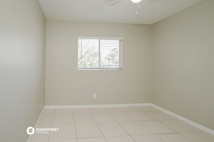 an empty room with a window and a tiled floor