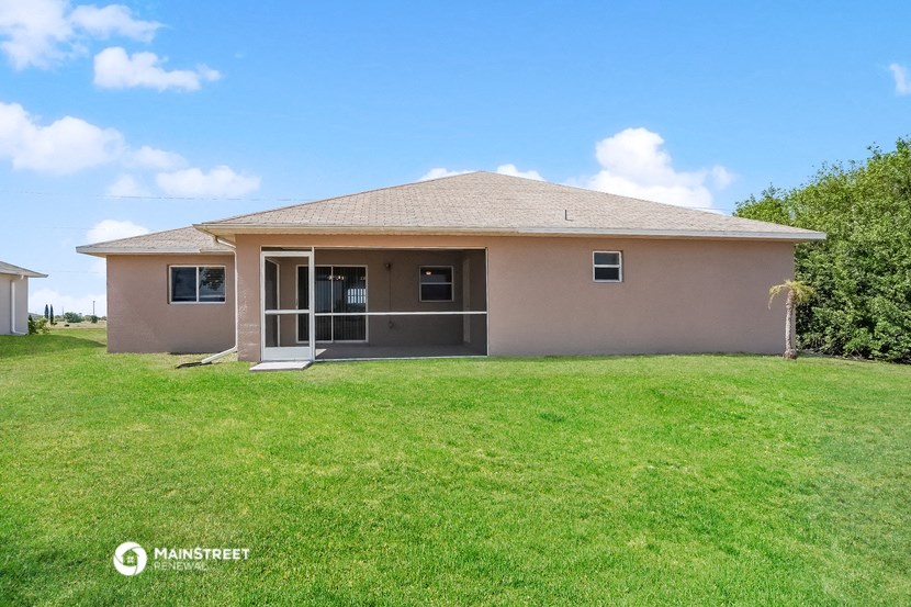 a beige house with a lawn and a door