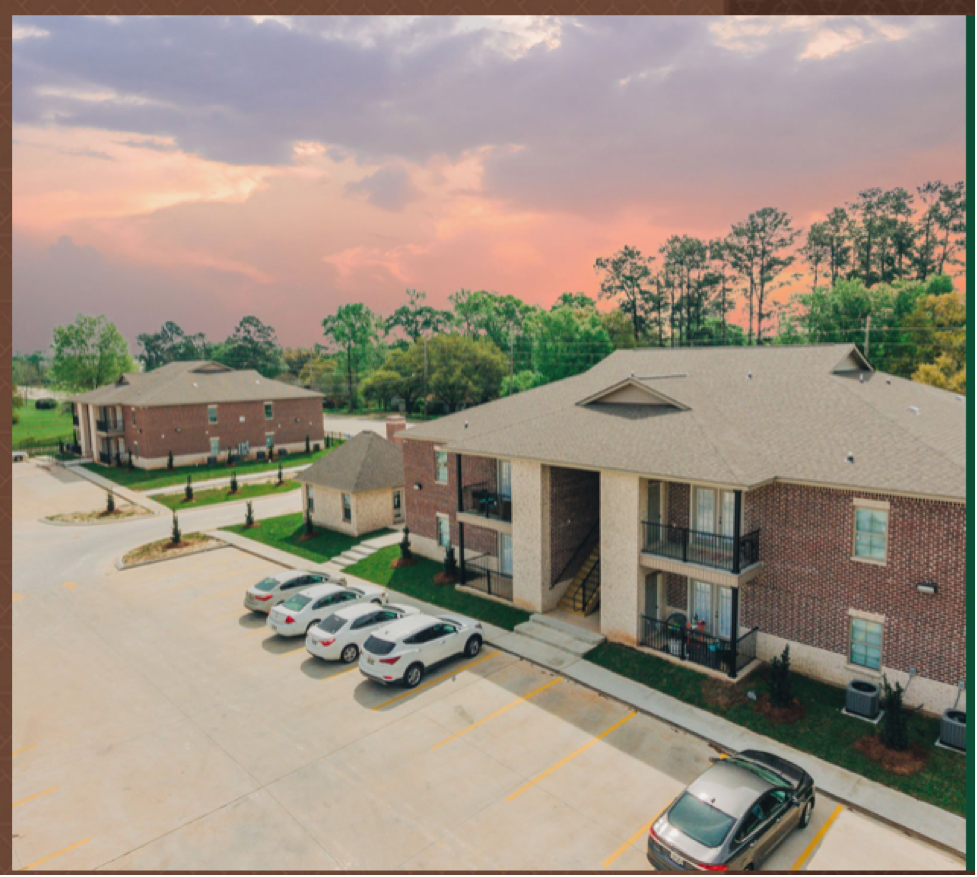 an aerial view of a building with cars parked in front of it