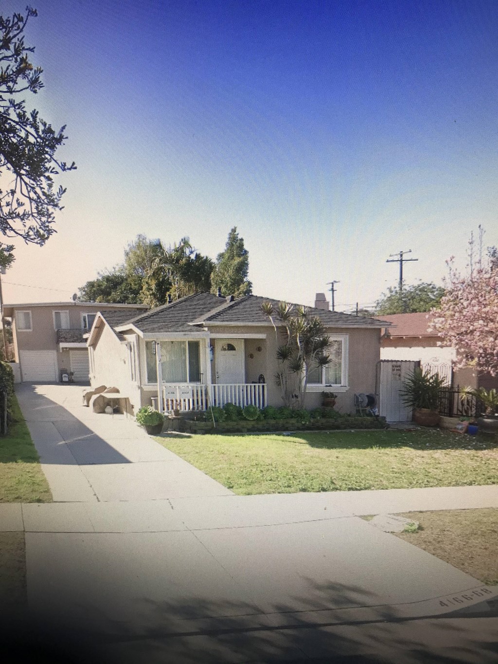 A residential street with houses and a sidewalk.