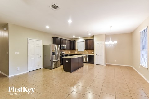 a large kitchen with stainless steel appliances and tiled flooring