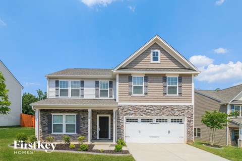 A two-story house with a garage is for sale.