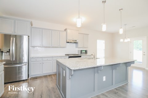A kitchen with a stainless steel refrigerator and a white countertop.