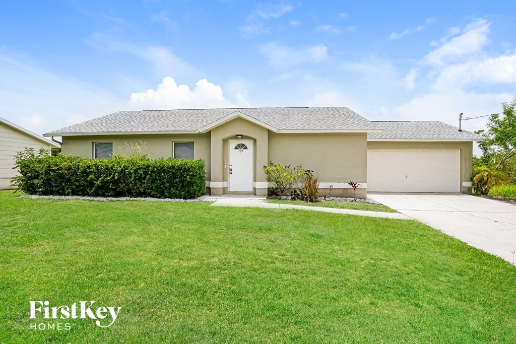 a beige house with a lawn and a white door