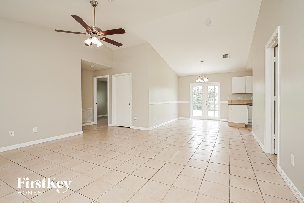 a large empty living room with a ceiling fan