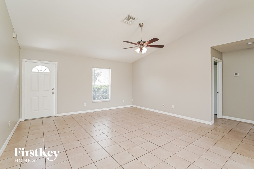 an empty living room with a ceiling fan