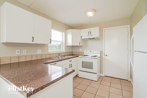 a kitchen with white appliances and white cabinets