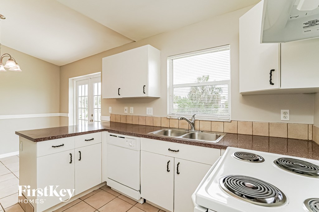 a kitchen with white cabinets and a stove top