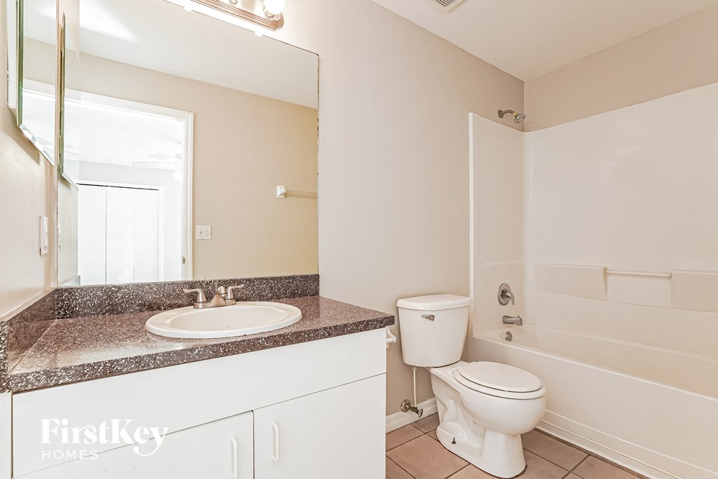 a bathroom with a toilet and a sink and a mirror
