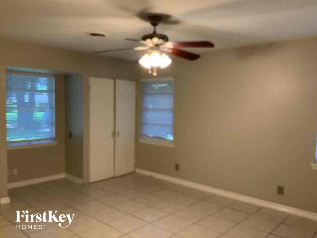 an empty living room with a ceiling fan