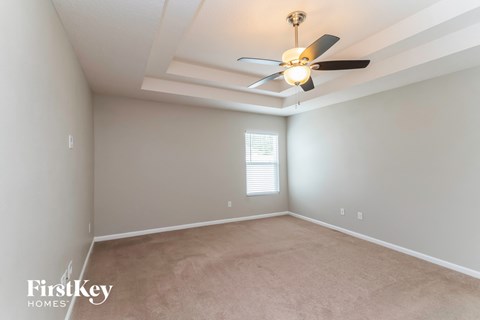 a living room with a ceiling fan and a carpet