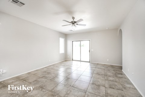 A spacious room with a ceiling fan and sliding glass doors.