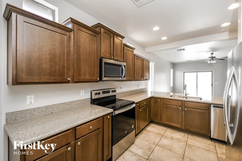 A kitchen with wooden cabinets and a granite countertop.