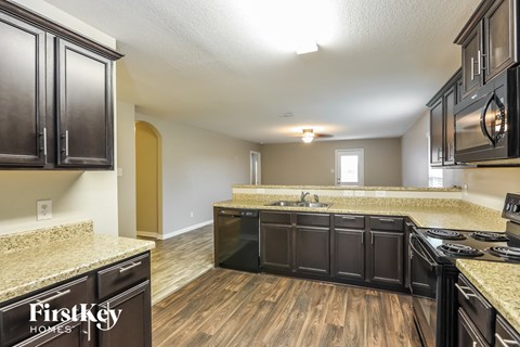 A kitchen with wooden cabinets and a granite countertop.