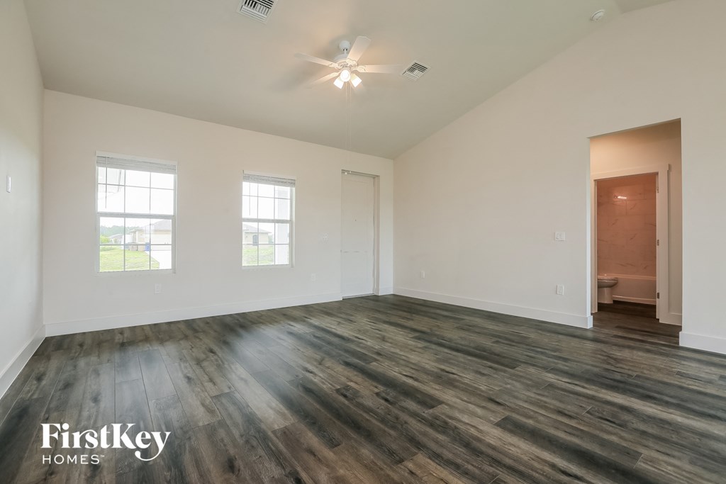 an empty living room with white walls and wood flooring