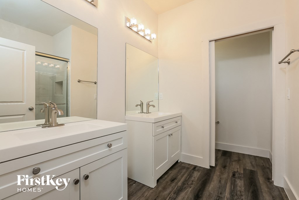 a bathroom with white cabinets and a sink and a mirror