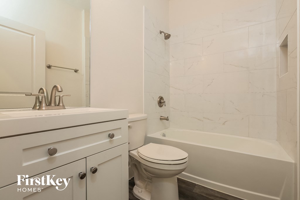 a bathroom with a toilet and a tub and a sink
