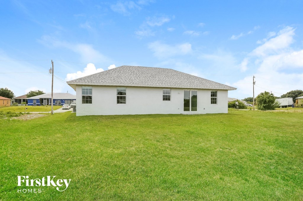 the front of a white house with a grassy yard