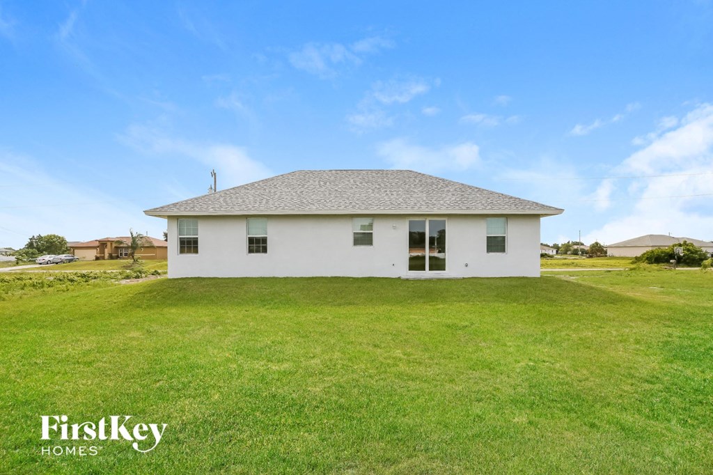 a small white house in a grassy field