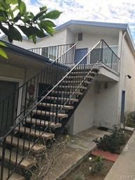 A staircase with a metal railing leads up to a balcony.