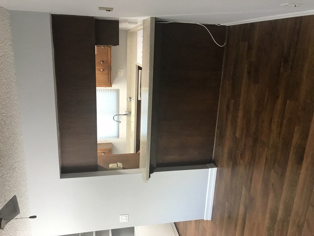 A mirror hanging on a wall with a reflection of a room.