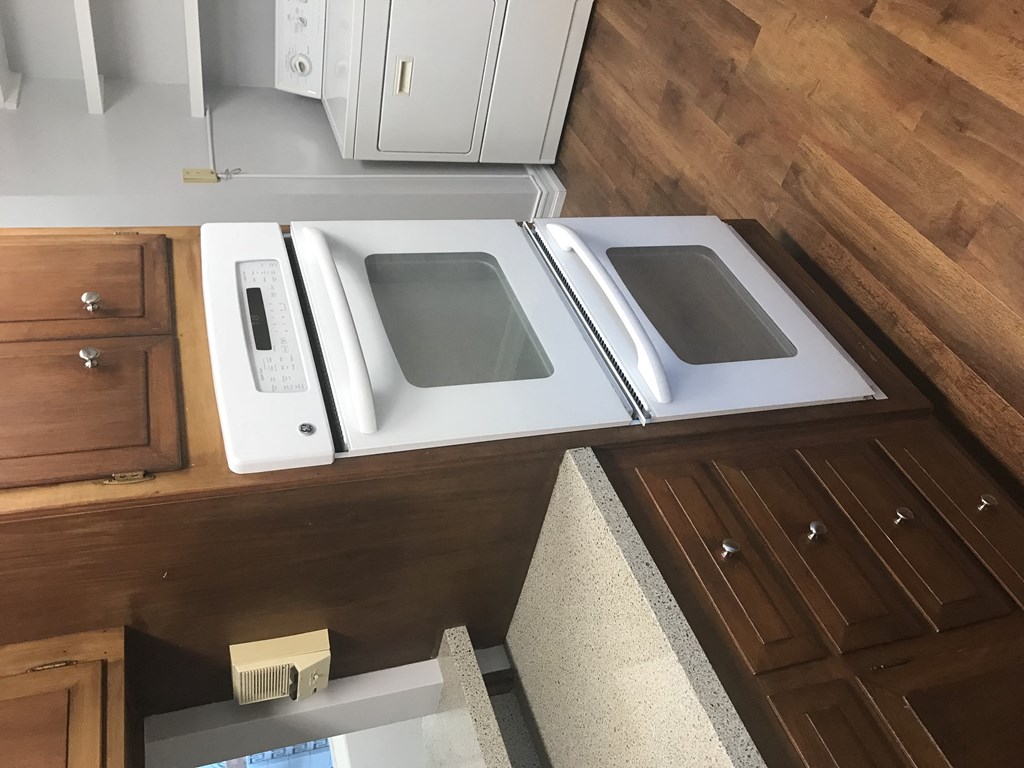 A white microwave and oven are on a countertop.