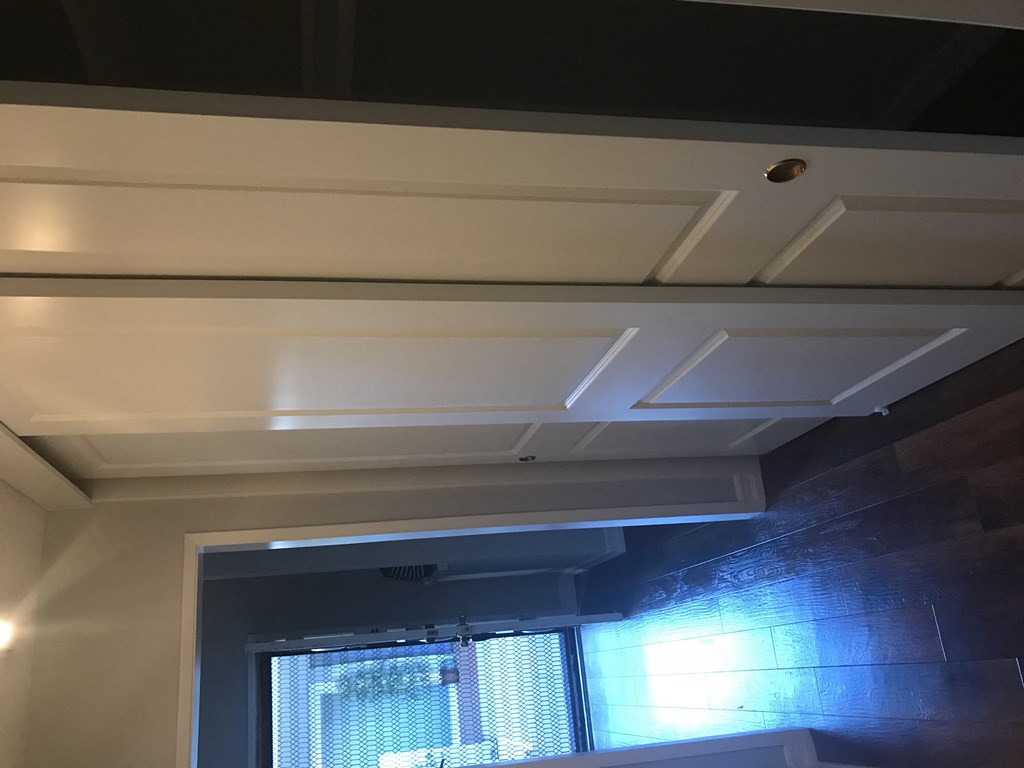 A white ceiling with a light fixture and a window.